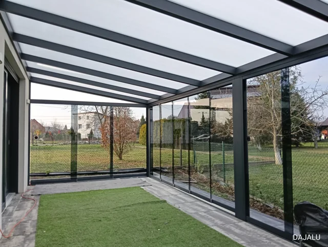 Aluminiowe zadaszenie ze stałym pokryciem i szklaną zabudową boków